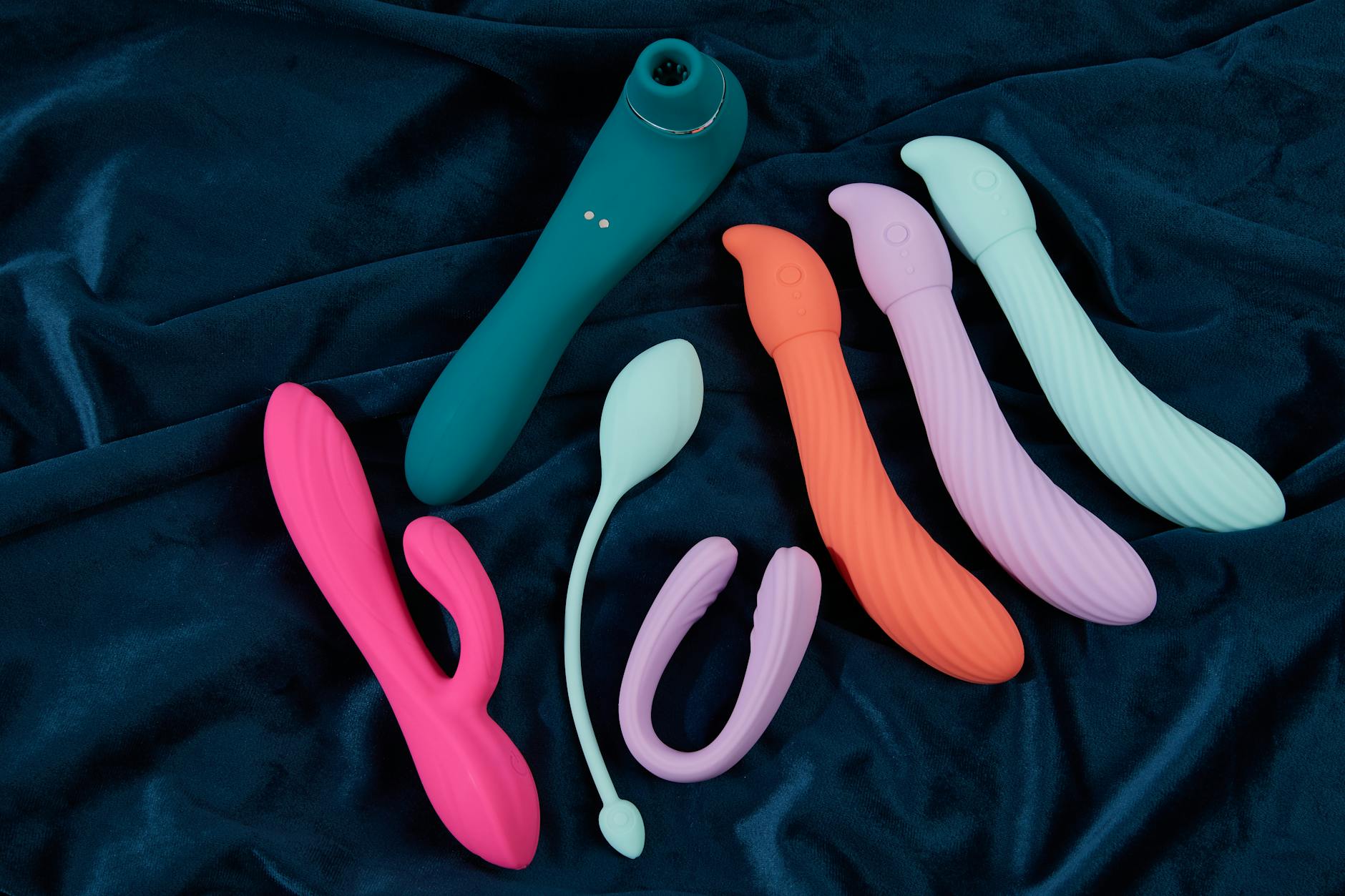 Hand holding a blue silicone vibrator against a purple background, showcasing modern sensuality and self-care