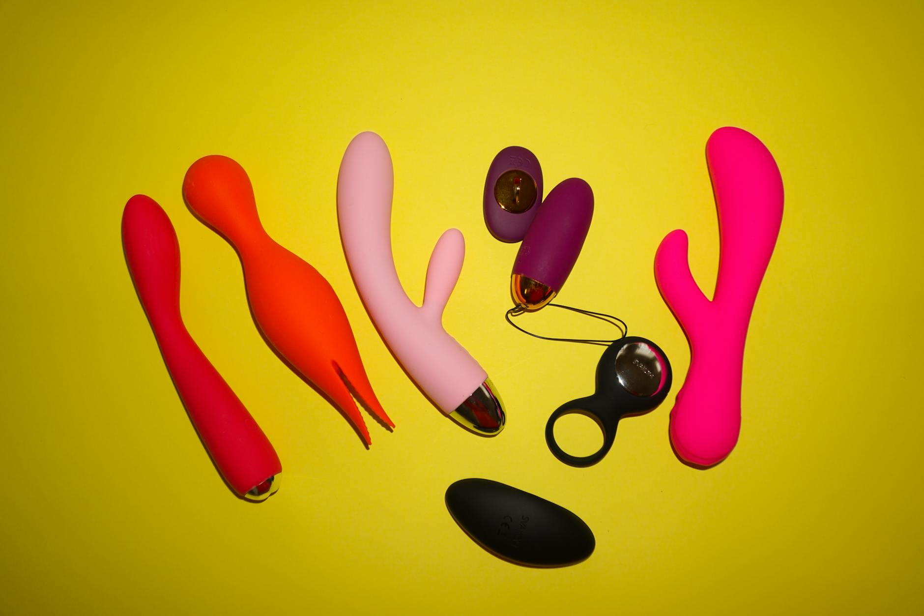 Colorful lemon clitoral vibrators and sex toys arranged on bright background